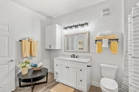 a bathroom with a toilet sink vanity and mirror