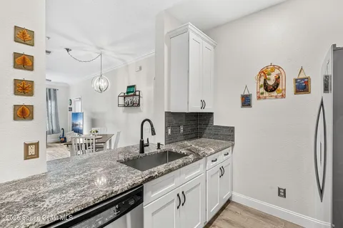 a kitchen with granite countertop a sink and cabinets