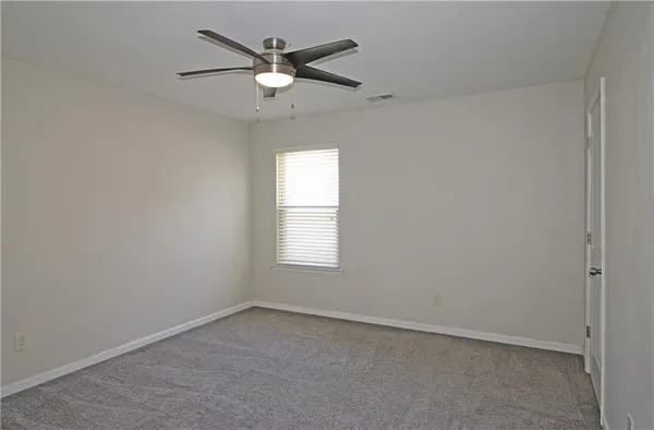 an empty room with a window and a fan