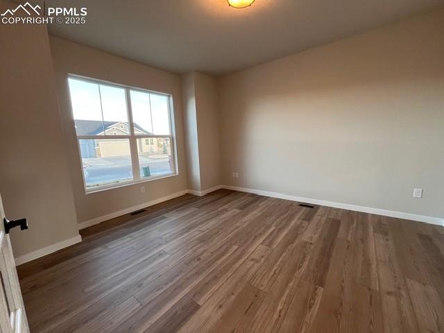 17570 Cerberus Court Monument, CO 80132 - Photo 7 of 15 an empty room with wooden floor and windows