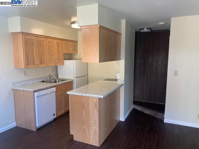 a kitchen with a sink refrigerator and cabinets