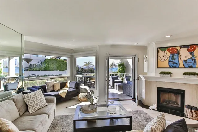 a living room with furniture a fireplace and a floor to ceiling window