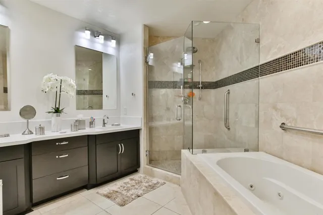 a bathroom with a tub sink shower and mirror