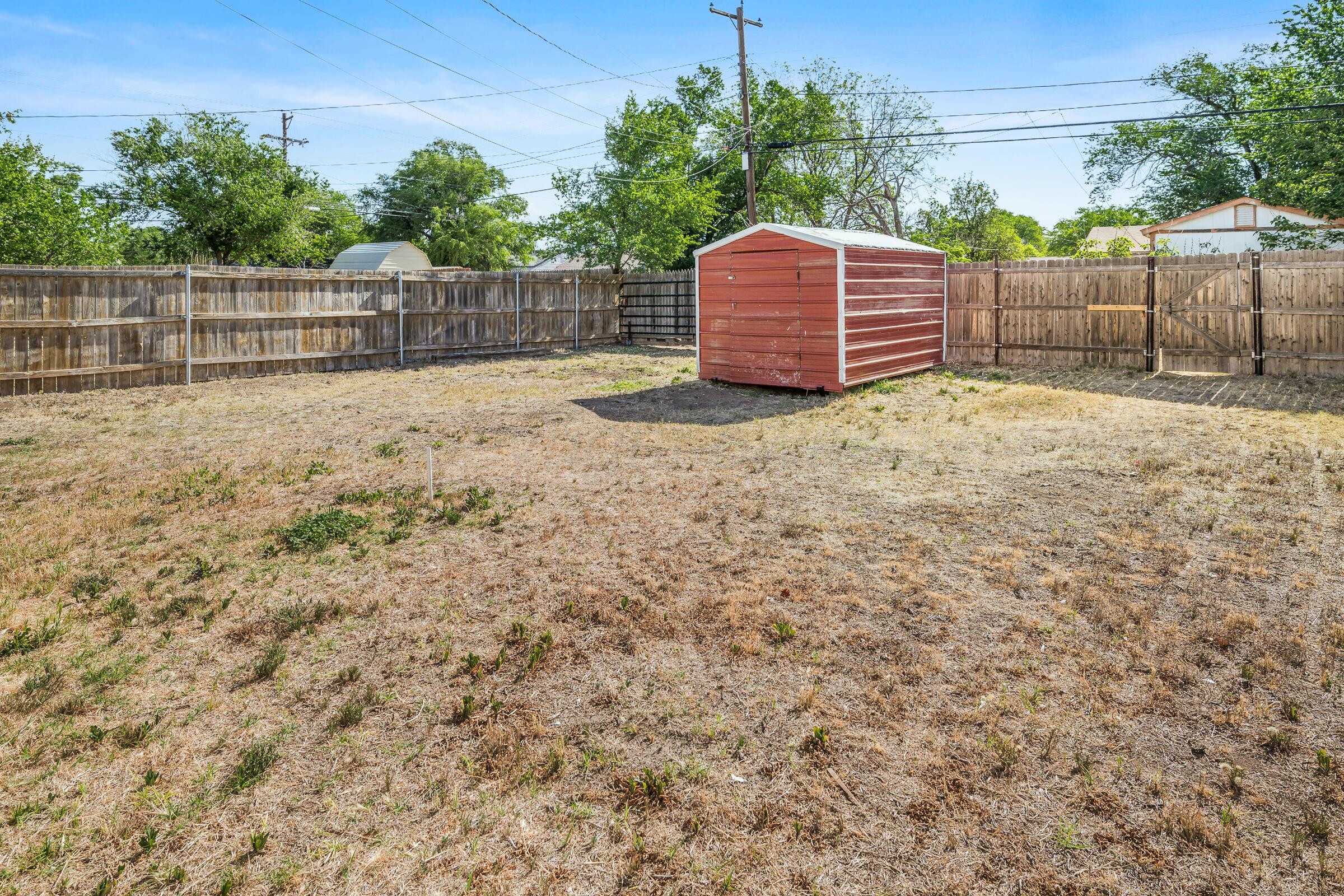 4429 Bowie Street Amarillo, TX 79110 - Photo 19 of 20 a view of a backyard with large trees and wooden fence