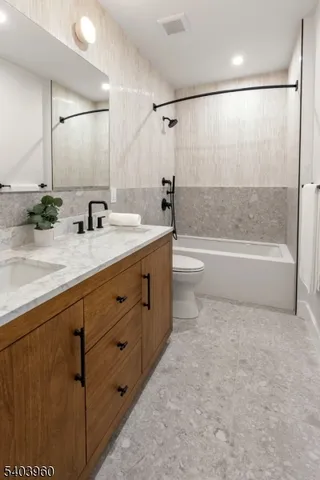 a bathroom with a bathtub shower sink vanity and toilet