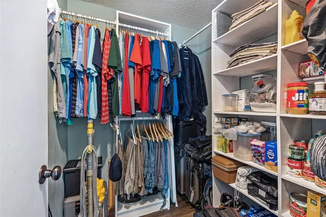 a view of walk in closet with clothes and shoes