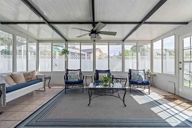 a living room with furniture and floor to ceiling windows