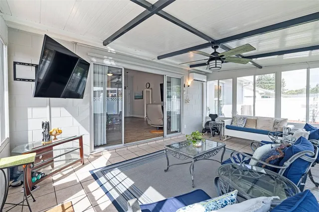 a living room with furniture a flat screen tv and a floor to ceiling window