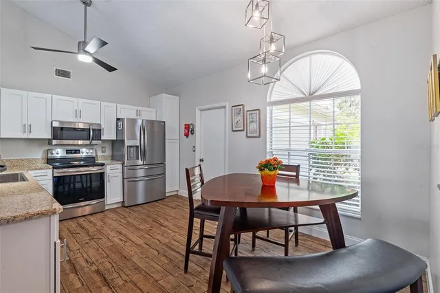 a kitchen with stainless steel appliances a table chairs and chandelier