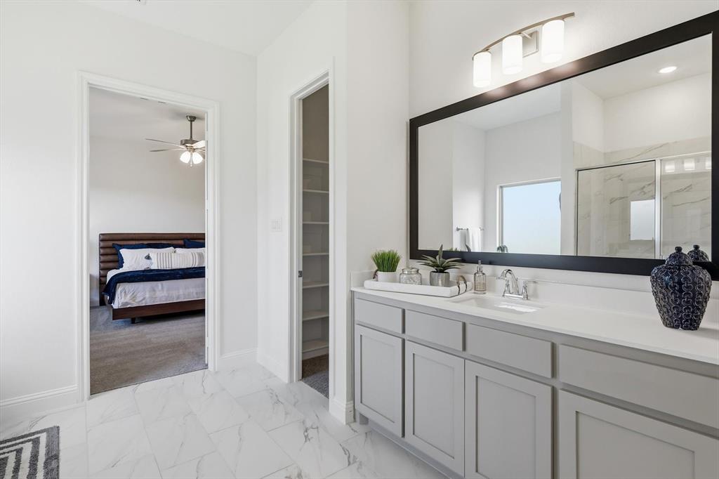 4017 Eagles Bluff Road Midlothian, TX 76065 - Photo 29 of 38 Bathroom vanity featuring dual sinks with chrome fixtures, light gray cabinetry, and a large framed mirror with integrated lighting