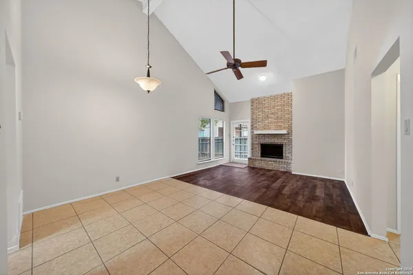 a view of an empty room with a fireplace and a window