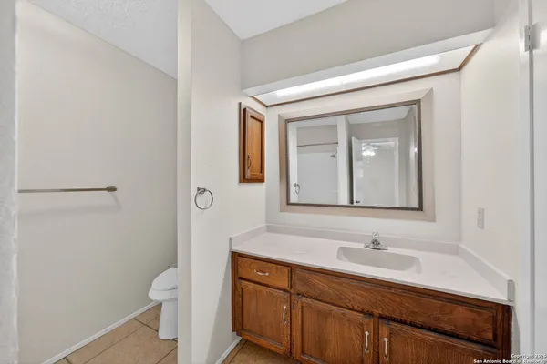 a bathroom with a sink a toilet and a mirror