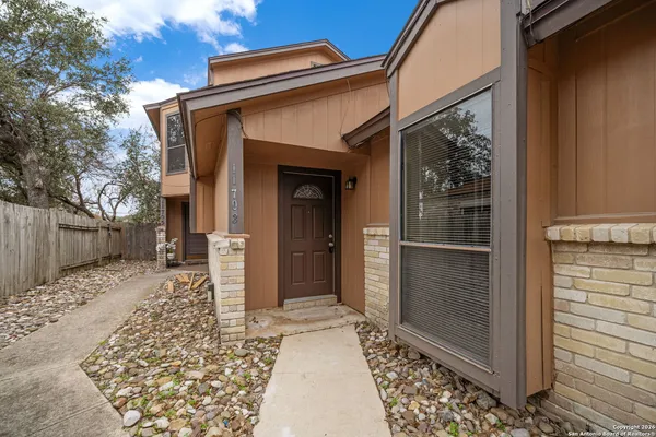 a view of a house with a door and wooden bench