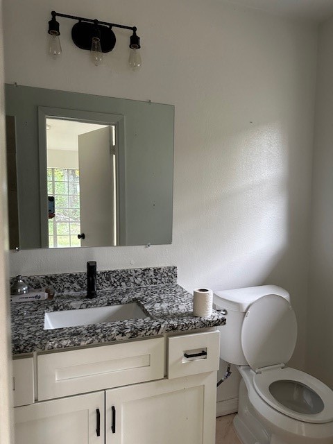 910 1/2 Oak Street Houston, TX 77018 - Photo 11 of 13 a bathroom with a granite countertop toilet sink and mirror