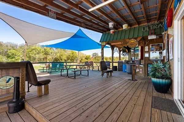 a view of a patio with table and chairs under an umbrella with wooden floor