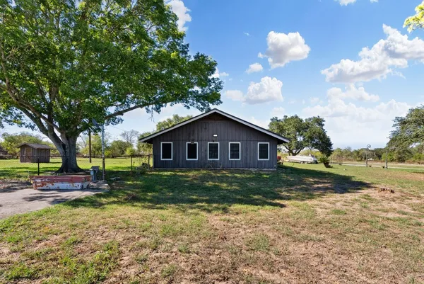a living room with furniture a table and kitchen view
