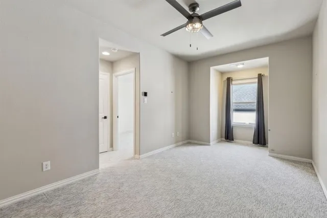 a view of a room with a ceiling fan and entryway