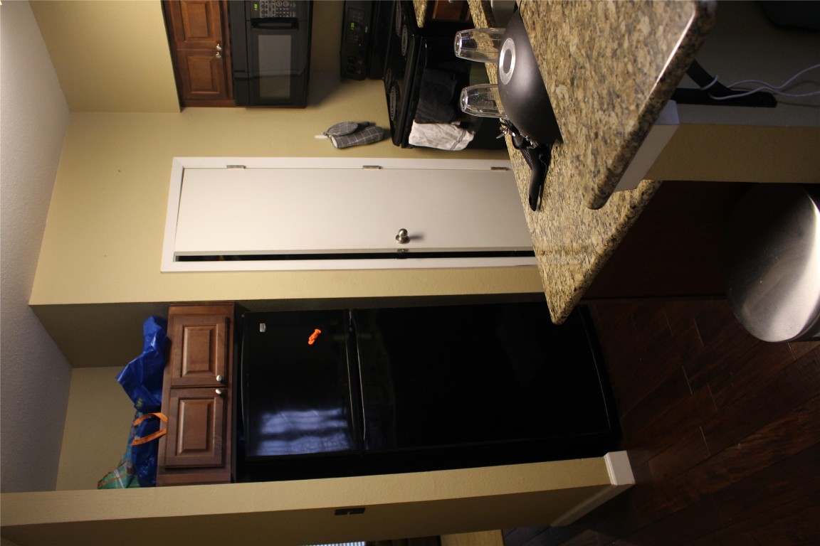 2801 Rio Grande Street, Unit 202 Austin, TX 78705 - Photo 12 of 38 a kitchen with granite countertop a refrigerator and a stove top oven