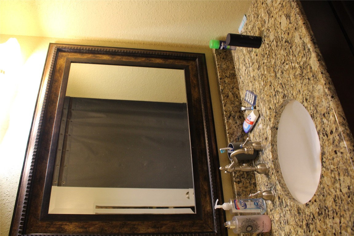 2801 Rio Grande Street, Unit 202 Austin, TX 78705 - Photo 22 of 38 a bathroom with a granite countertop sink and mirror