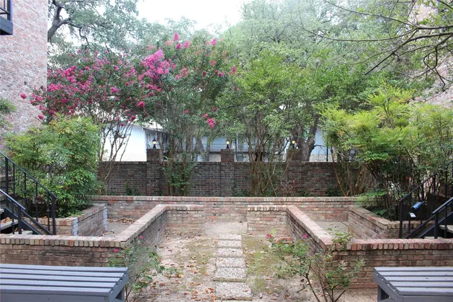 a view of house with a yard and potted plants