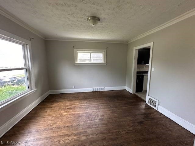 1752 South Taylor Road Cleveland, OH 44118 - Photo 4 of 14 Unfurnished bedroom with multiple windows, a textured ceiling, and dark wood-type flooring