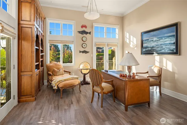 a kitchen with stainless steel appliances kitchen island granite countertop a dining table chairs and white cabinets with wooden floor