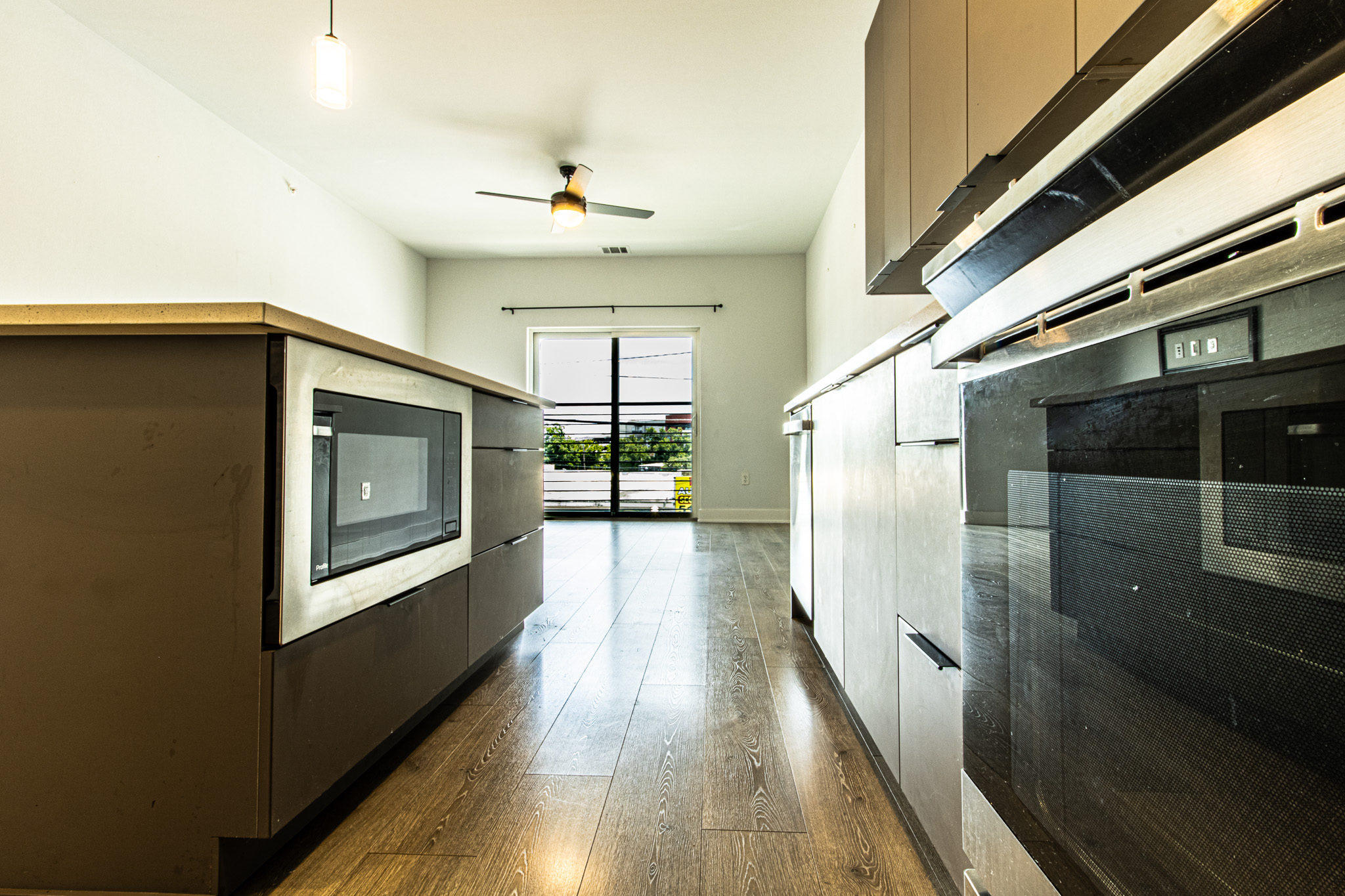 2220 Webberville Road, Unit 202 Austin, TX 78702 - Photo 12 of 27 Warm wood flooring and modern cabinetry anchor this stylish culinary space featuring a sliding glass door.