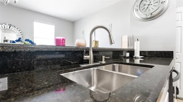 a close view of a sink a counter space and a fireplace in room