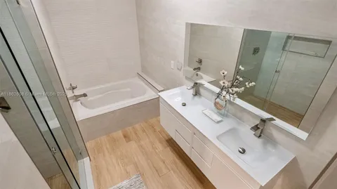 a bathroom with a double vanity sink a mirror and shower