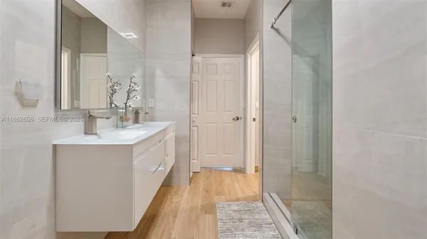 a bathroom with a double vanity sink a mirror and shower