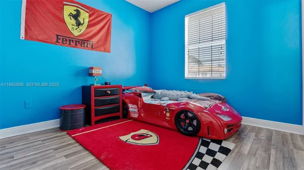 a bed sitting in a bedroom next to a window with red lamp