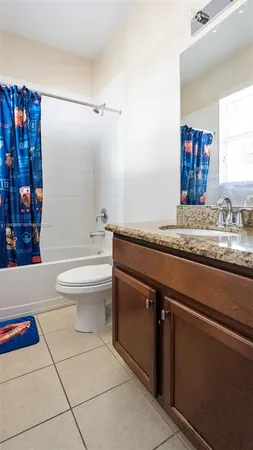 a bathroom with a granite countertop sink a toilet and shower
