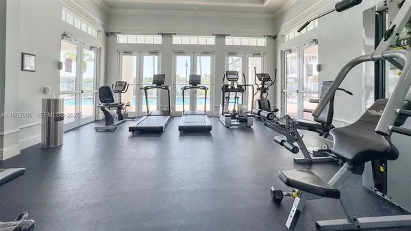 a view of a room with gym equipment and floor to ceiling windows