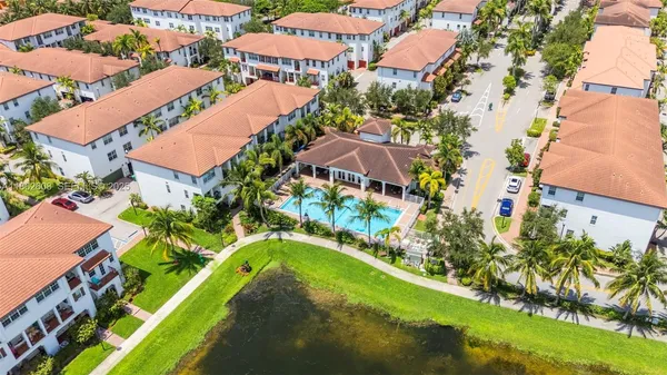 an aerial view of residential houses with outdoor space and swimming pool