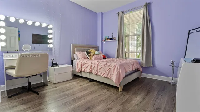 a bedroom with a bed window and table chair