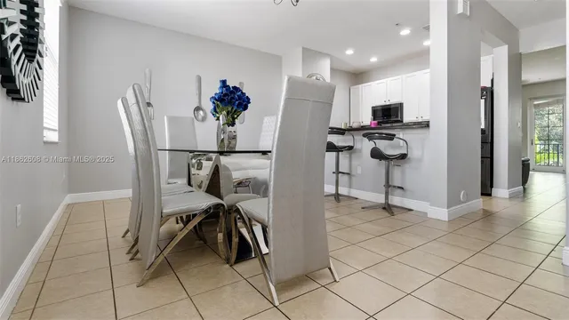 a view of a kitchen with refrigerator and dining table