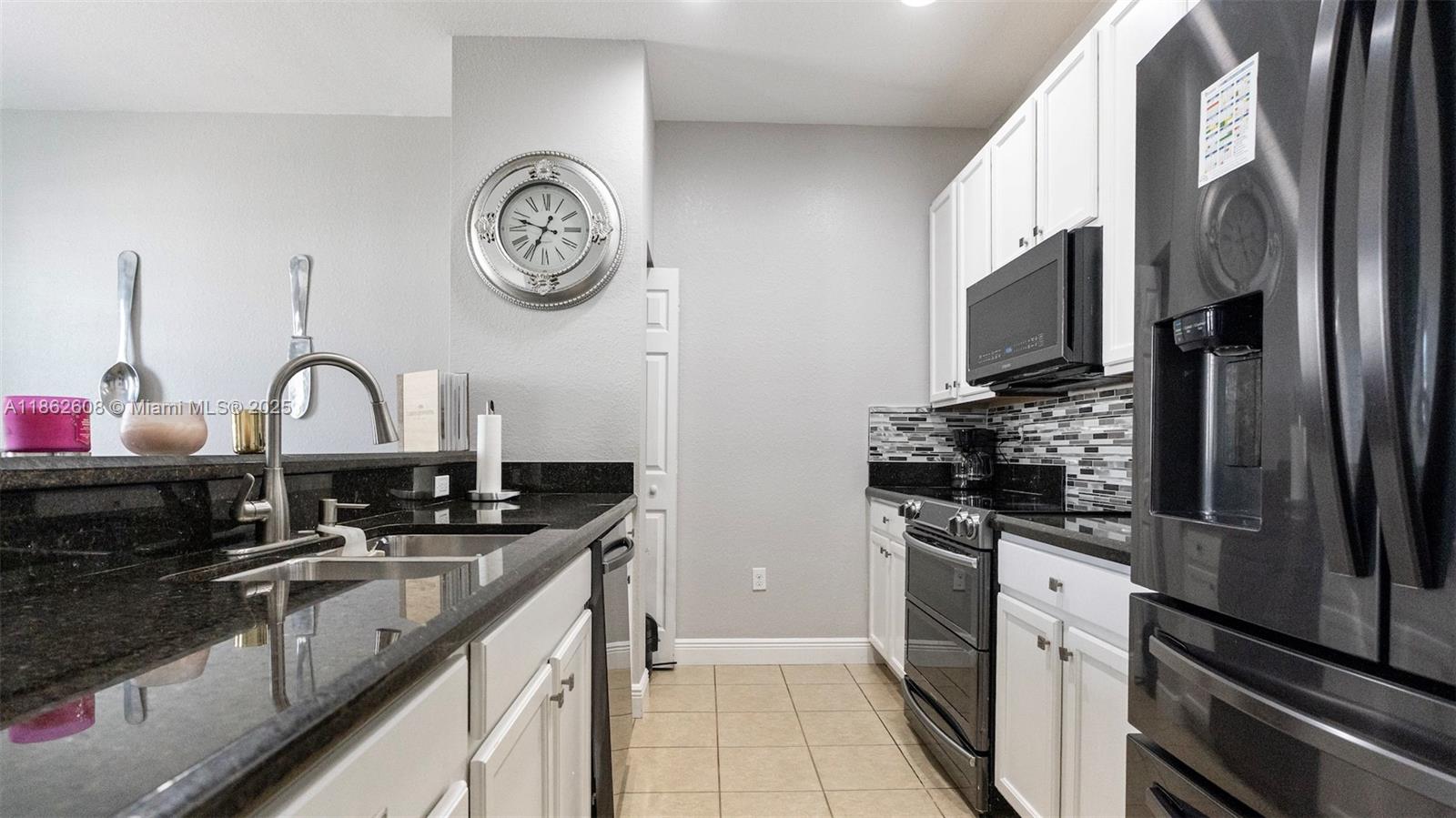 2547 Southwest 119th Terrace Miramar, FL 33025 - Photo 10 of 41 a kitchen with a sink cabinets and stainless steel appliances