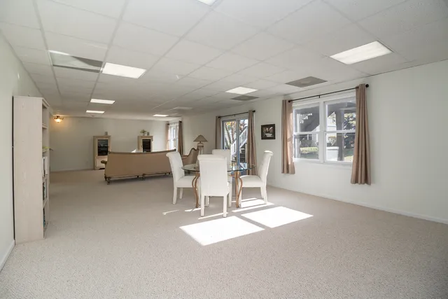 a living room with furniture a dining table and a large window