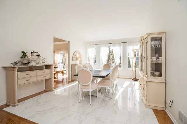 a living room with furniture a dining table and chairs with wooden floor