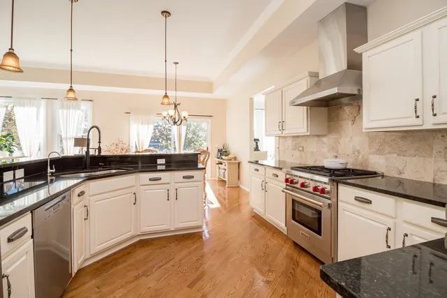 a kitchen with stainless steel appliances white cabinets and a wooden floor