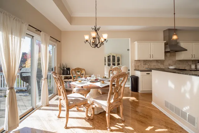 a view of a dining room with furniture a chandelier and wooden floor