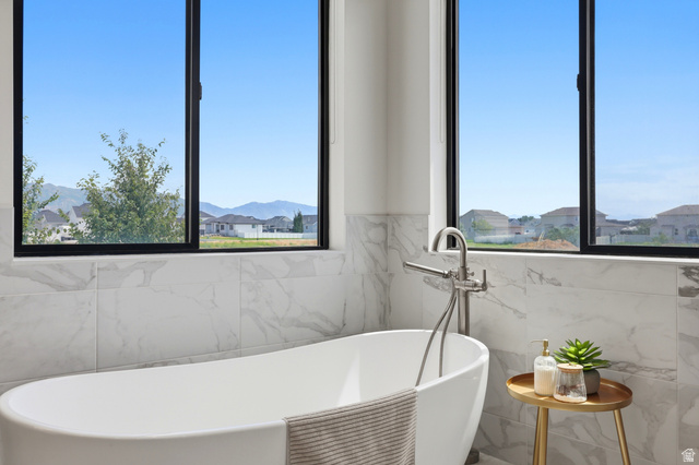 4331 West 475 South West Point, UT 84015 - Photo 11 of 46 Freestanding soaking tub with a floor-mounted faucet, complemented by large format wall tile
