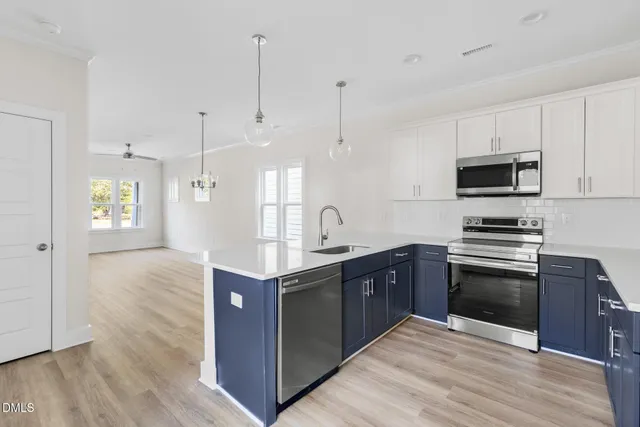 a kitchen with stainless steel appliances granite countertop a sink a stove top oven a counter space and cabinets