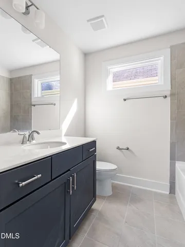 an empty room with windows and ceiling fan