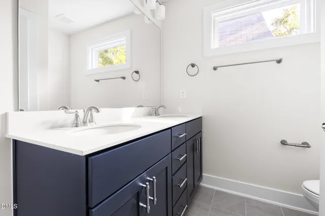 a bathroom with a double vanity sink mirror and shower