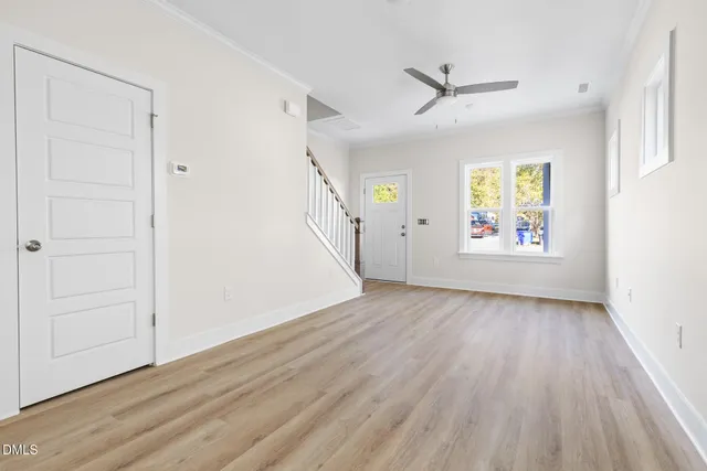 an empty room with wooden floor and windows
