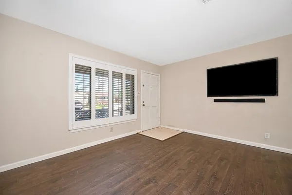 a view of a livingroom with wooden floor and windows