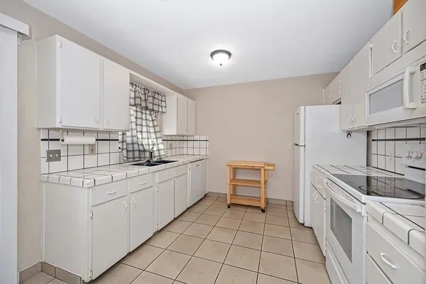 a kitchen with a sink stove and cabinets