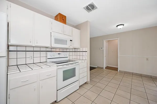 a kitchen with a stove top oven and cabinets