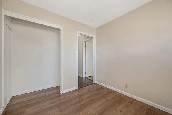 a view of an empty room with wooden floor